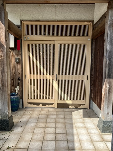 小林エコ建材の檜調ラッピング玄関からアルミ色の引戸への施工前の写真1