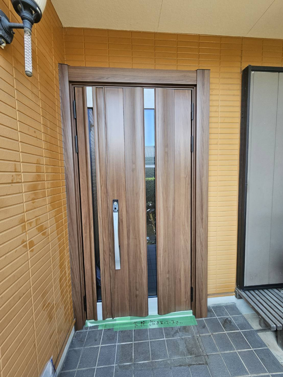 リフォームショップミナトの玄関ドアを一新!木目調でナチュラルな印象に変身✨の施工後の写真1