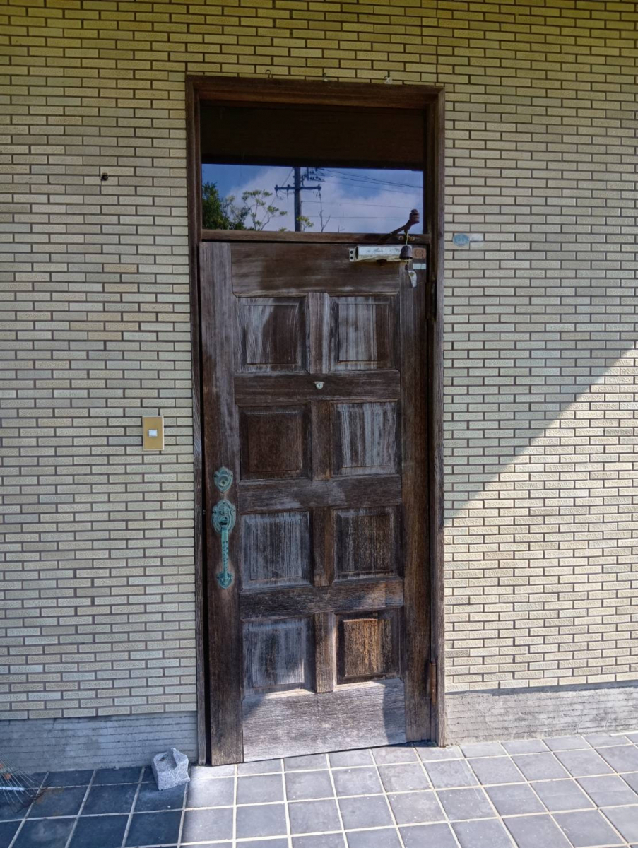 石田ガラスサッシ販売の外壁と床タイルに調和する玄関ドアにリフォームしたい！の施工前の写真1