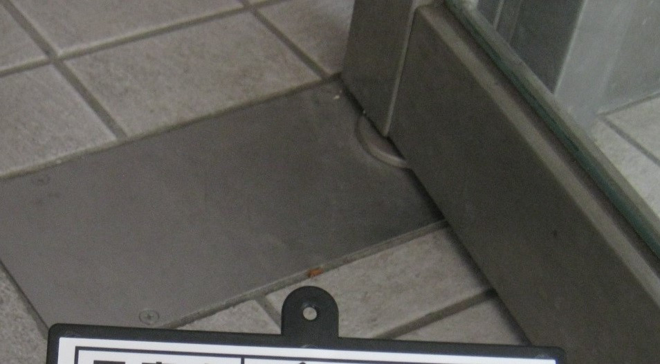県南サッシトーヨー住器のフロアヒンジとは？　開き戸の軸側の床に埋め込まれたドアを適切な速度で開閉させる装置です。の施工前の写真1