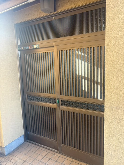 井上住器の平塚市【玄関引戸リフォーム工事】アルミ製玄関引戸から断熱性能ありのリシェント玄関引戸への施工前の写真1