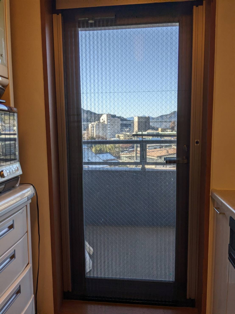 アイプラン今井ガラス建材のマンションの勝手口ドアに収納式網戸を取付の施工後の写真1