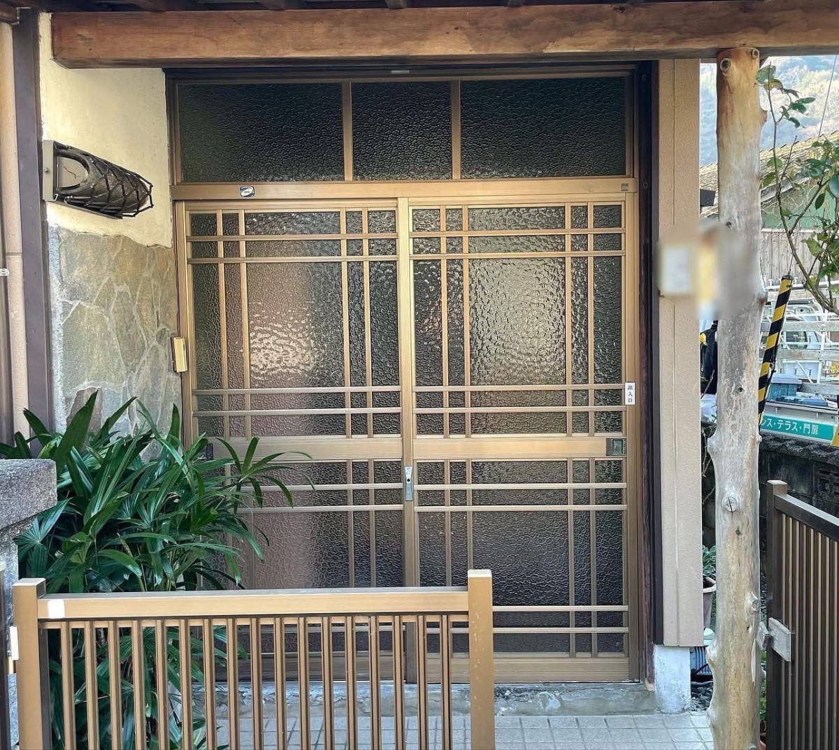 大山硝子のアルミサッシを木目調引戸へ交換！和モダンな玄関リフォームの施工前の写真1