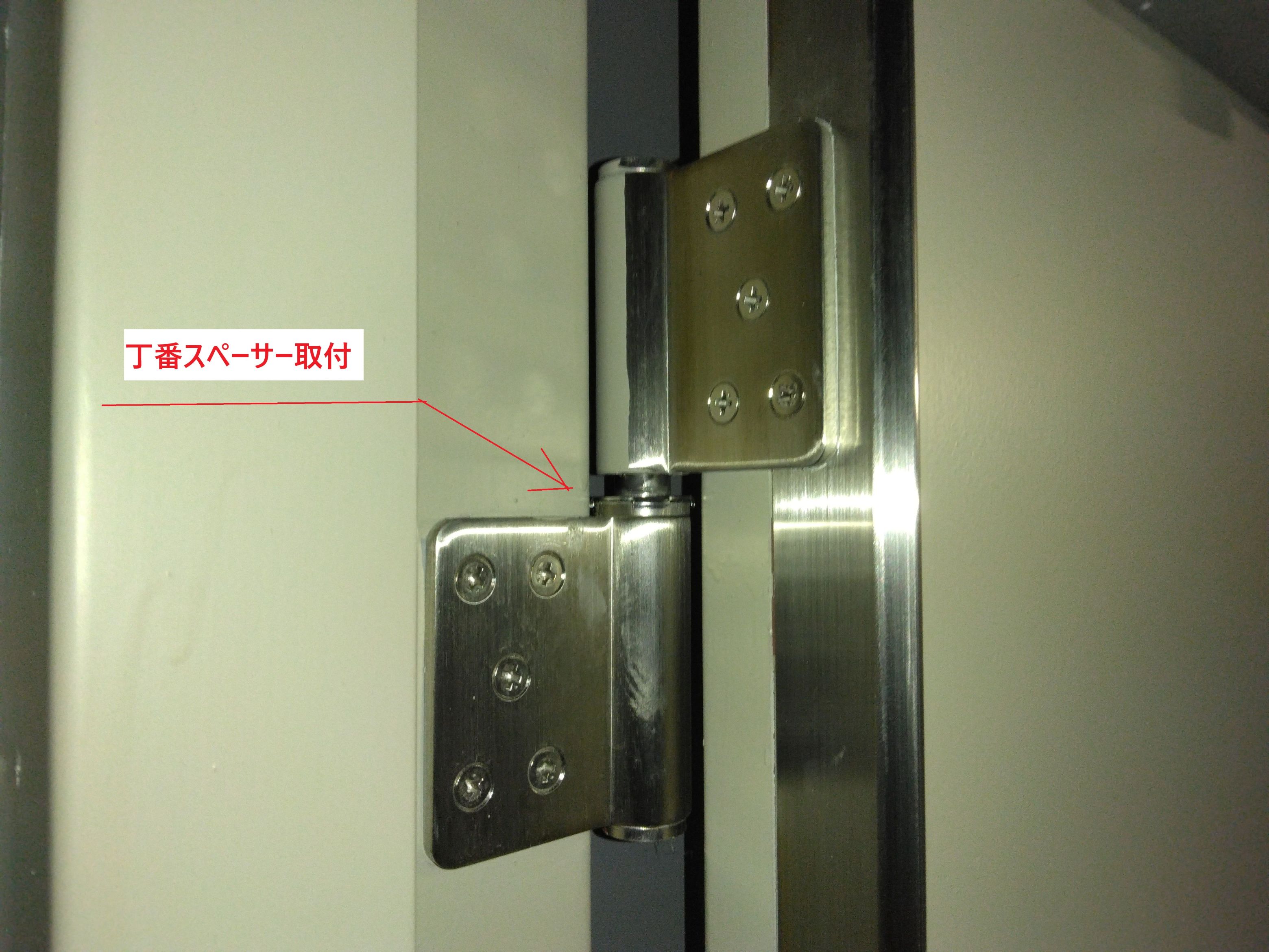 小島硝子のスチール製ドアの丁番部分に、SUS製の丁番スペーサーを取付。の施工事例詳細写真2