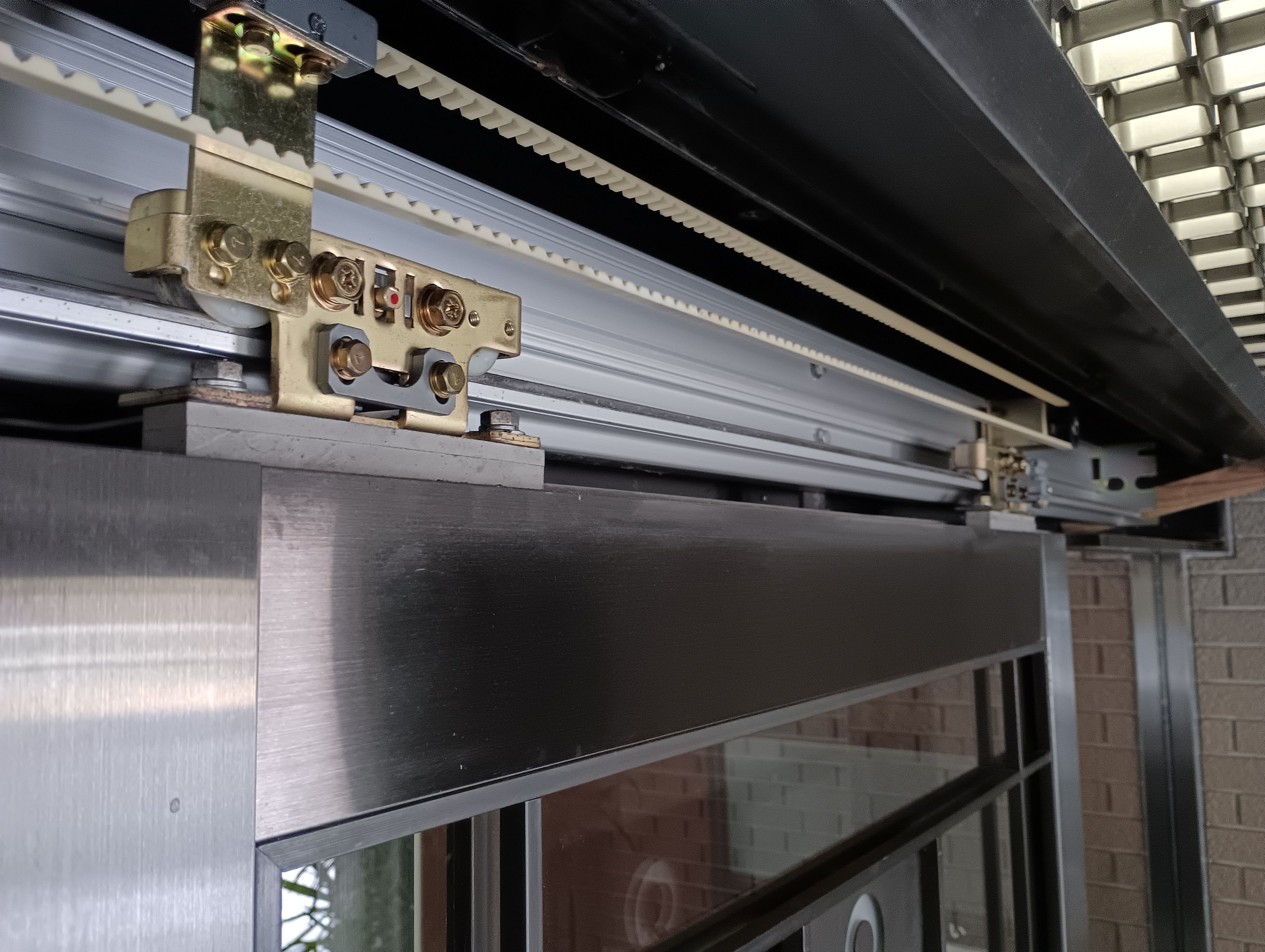 小島硝子の劣化した自動ﾄﾞｱの吊り車を交換工事。の施工前の写真2