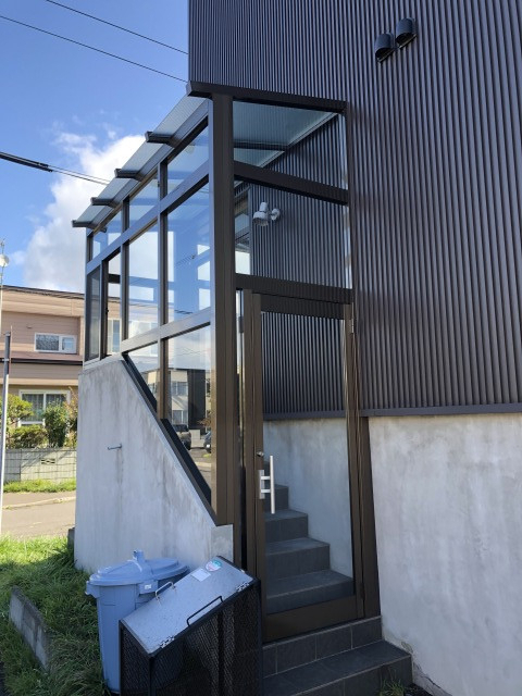 手稲ガラスの【ツインガードⅢ】階段に合わせて加工した大型風除室の施工後の写真1