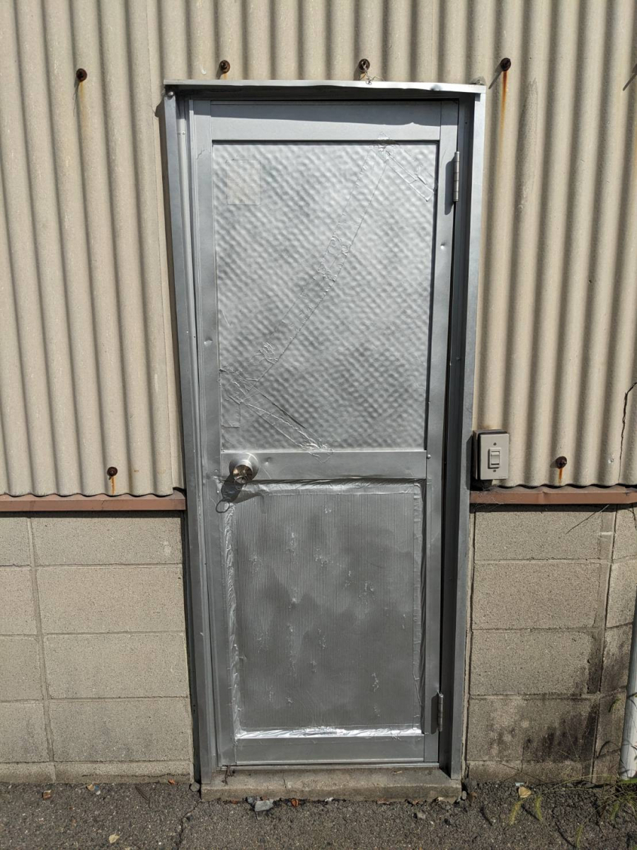中央アルミ住器の倉庫入口ドアの取替（桑名市）の施工前の写真1