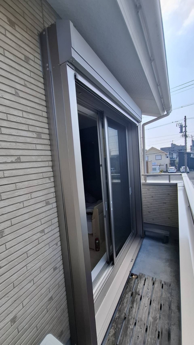 中央アルミ住器の2階バルコニーの掃き出し窓にLIXIL後付けシャッター【四日市市】の施工後の写真1