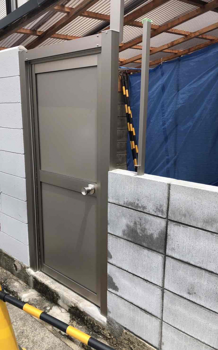 共栄アルミトーヨー住器のブロックの間に勝手口ロンカラーガラスドア取付工事の施工後の写真1